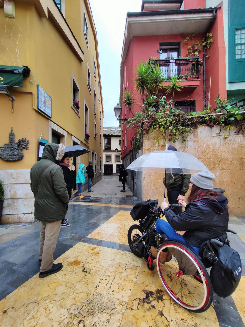 Silla de ruedas con handbike eléctrico de Batec Mobility bajo la lluvia y con paraguas