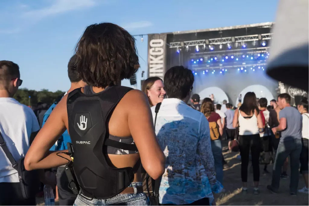 A young woman with a hearing impairment using a vibrating backpack at Primavera Sound. 