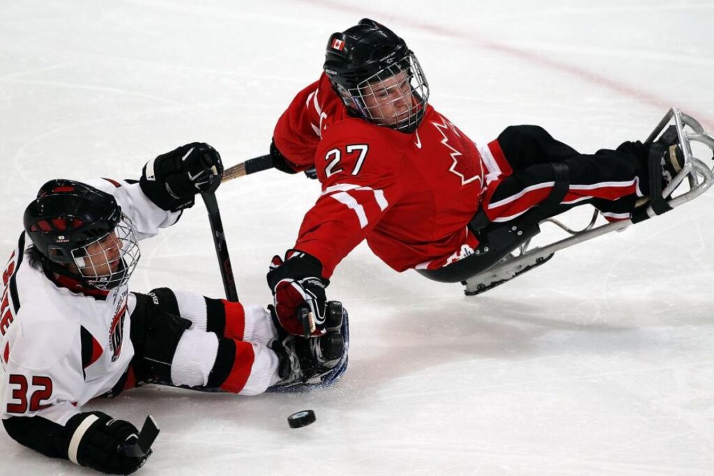 Two wheelchair ice hockey players during a match.