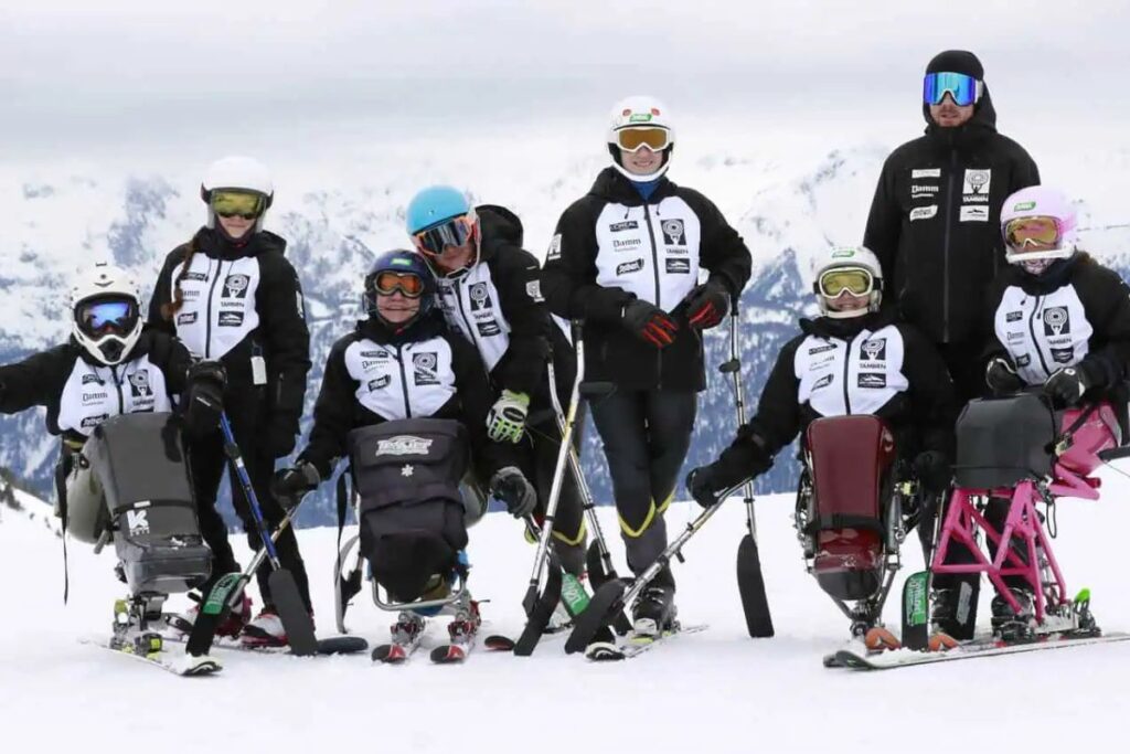 Adapted ski team for people with disabilities on the snow, using equipment such as monoskis for wheelchair skiing.