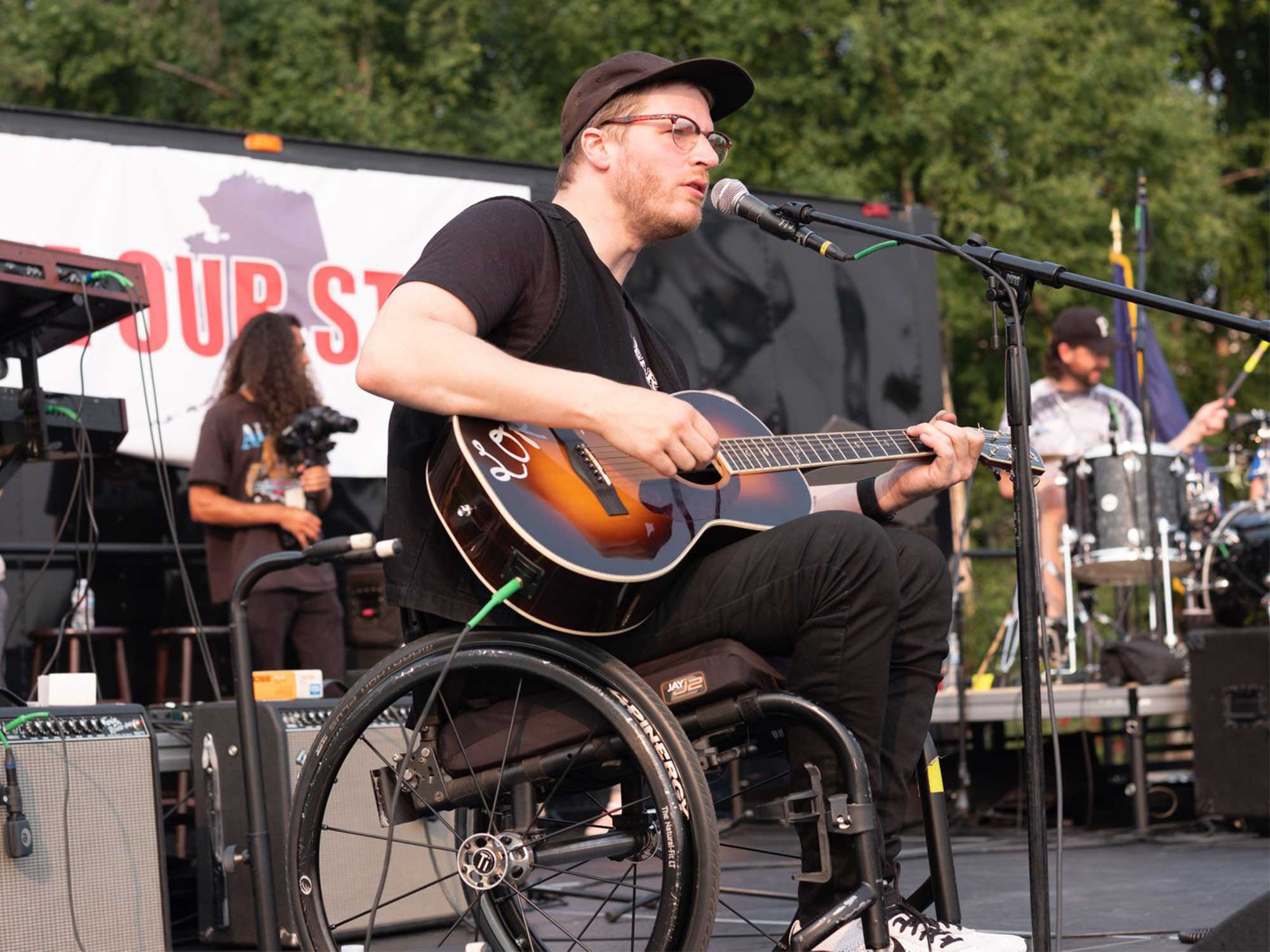 musicos con discapacidad guitarrista en silla de ruedas durante un concierto