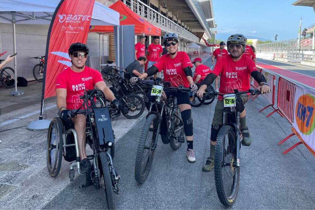 Persona en silla de ruedas y su handbike junto a personas en bicicleta haciendo deporte en una actividad inclusiva