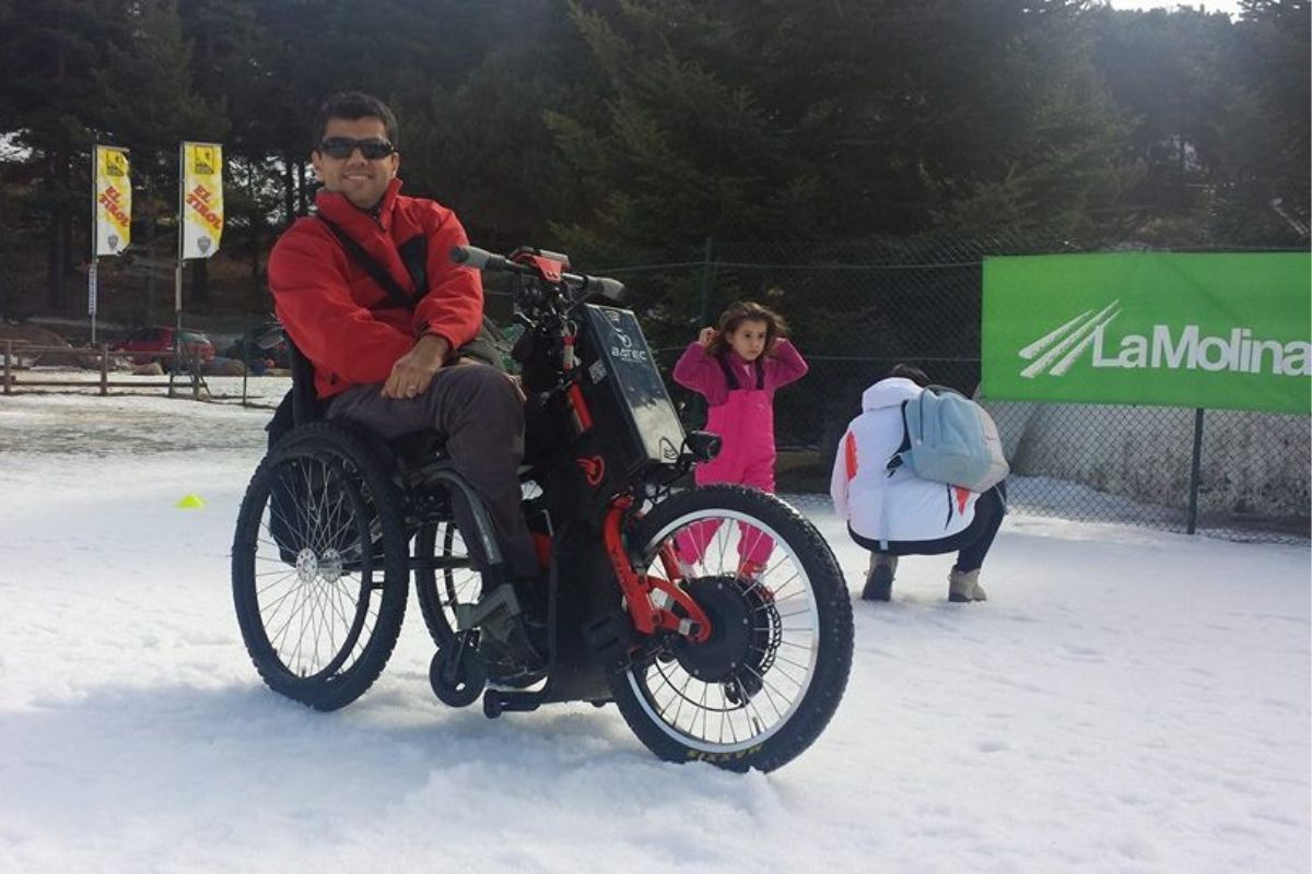 usuario de silla de ruedas y batec mobility en la estación de esquí la molina para practicar esquí adaptado en un día soleado y nevado