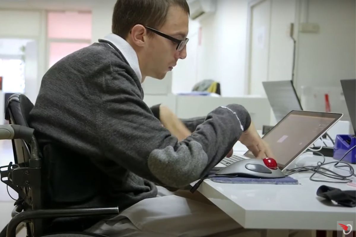 Axel Libori software developer, working with his wheelchair. A man working on his computer and sitting on his wheelchair.