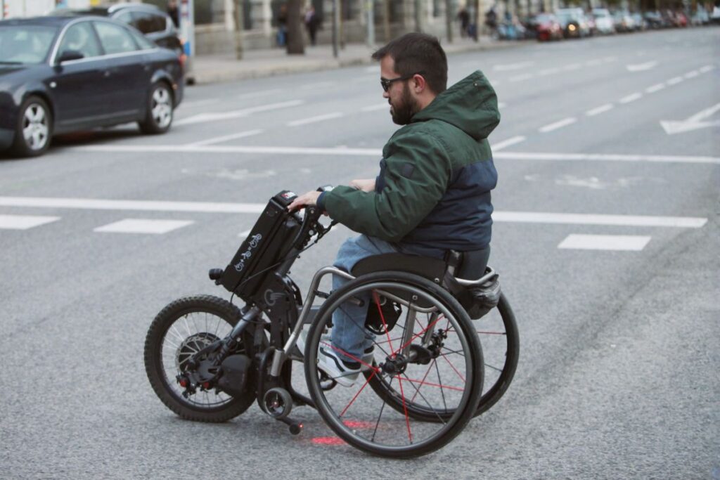 Usuario de silla de ruedas usando ruedas spinergy para un paseo por la ciudad